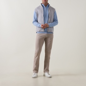 Model wearing Peter Millar Ardent Air Half-Zip Sweatshirt in Lakeside blue, styled with beige chinos and white trainers.
