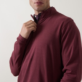 Model wearing Peter Millar bordeaux quarter-zip sweatshirt, close-up showing zip collar detail and smooth fabric finish.
