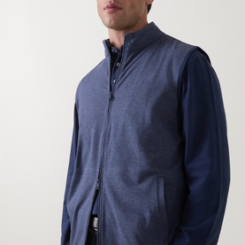 Model wearing Peter Millar navy zip-up vest with stand collar, styled over a matching navy long-sleeve top.