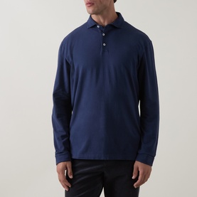 Model wearing Peter Millar navy long-sleeve polo shirt in cotton-spandex blend, paired with dark trousers.