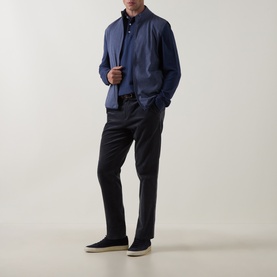 Model wearing Peter Millar navy cotton zip-neck sweatshirt, styled with dark trousers and cream canvas shoes.
