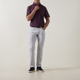 Model wearing Peter Millar eb66 Mid-Rise Straight Leg Jeans in grey, styled with a burgundy polo shirt and navy shoes.