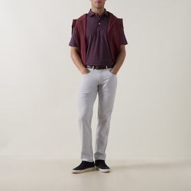Model wearing Peter Millar eb66 Mid-Rise Straight Leg Jeans in grey, styled with a burgundy polo shirt and navy trainers.