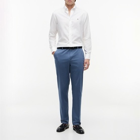 Model wearing Tommy Hilfiger Aegean Sea slim trousers with white shirt and black loafers