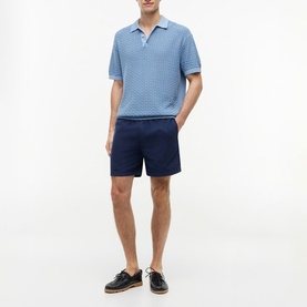 Model wearing Tommy Hilfiger Carbon Navy shorts with blue textured polo shirt and dark leather boat shoes.