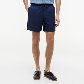 Model wearing Tommy Hilfiger Carbon Navy drawstring shorts, styled with dark leather boat shoes, mid-thigh length with side pockets.