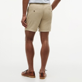 Model wearing Tommy Hilfiger Sandalwood chino shorts, rear view, styled with brown leather boat shoes.