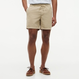 Model wearing Tommy Hilfiger sandalwood shorts with drawstring waist, styled with a white tee and brown boat shoes.