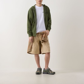 Model wearing Dickies Bettsville Logo T-Shirt in white, styled with olive zip hoodie, tan shorts, and grey trainers.