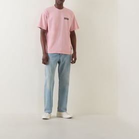 Model wearing Dickies Bridal Rose crew neck T-shirt with light wash straight-leg jeans and white low-top trainers.