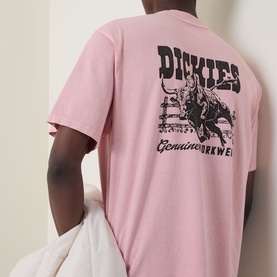 Model wearing Dickies Crew Neck T in Bridal Rose, showing back graphic print with bull rider and Genuine Workwear text.