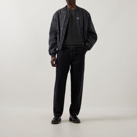 Model wearing Dickies Buchtell Logo T-Shirt in black, styled with dark bomber jacket and black tapered jeans and loafers.