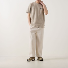 Model wearing Dickies Darrtown Logo T-Shirt in Eucalyptus, styled with cream wide-leg trousers and khaki trail trainers.