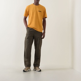 Model wearing Dickies sunflower crew neck T-shirt with olive cargo trousers and tan trainers.