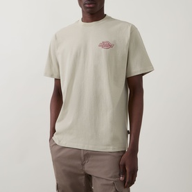 Model wearing Dickies Millville Logo T-Shirt in Eucalyptus, with small chest logo graphic, paired with taupe trousers.