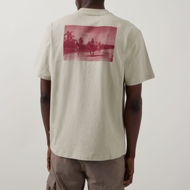 Model wearing Dickies Millville Logo T-Shirt in Eucalyptus, showing back with pink tropical graphic print, crew neck, short sleeves.