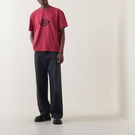 Model wearing Dickies Garnet Crew Neck T-shirt with chest logo graphic, styled with dark wide-leg trousers and black chunky shoes.