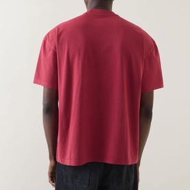 Model wearing Dickies Garnet Crew Neck T-shirt, rear view, relaxed fit, styled with dark trousers.