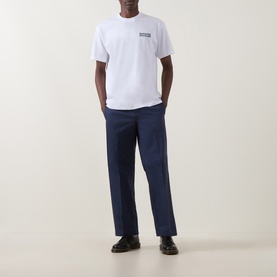 Model wearing Dickies white cotton crew neck T-shirt with navy trousers and black shoes.