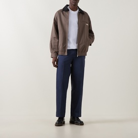Model wearing Dickies white crew neck T-shirt, styled with brown zip-up jacket, navy trousers and black loafers.
