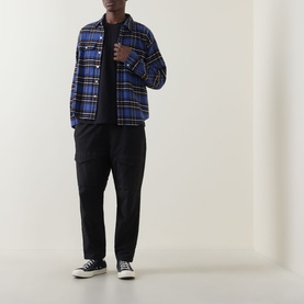 Model wearing Dickies black crew neck T-shirt, styled with blue plaid overshirt, black cargo trousers and navy canvas trainers.