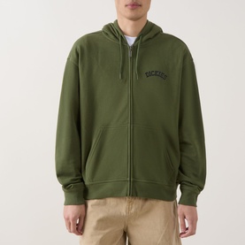 Model wearing Dickies Bettsville Logo Zip Hoodie in Cypress green with navy chest logo, styled with beige chinos.