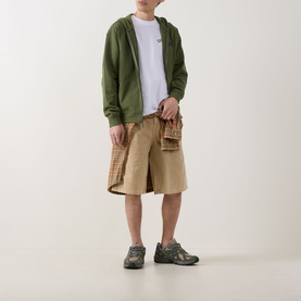 Model wearing Dickies Bettsville Logo Zip Hoodie in Cypress green, styled with beige check shorts and grey trail trainers.