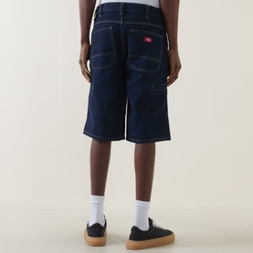 Model wearing Dickies rinsed denim shorts, rear view, styled with white socks and black flatform trainers