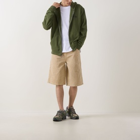 Model wearing Dickies 958 Loose Denim Shorts in Eucalyptus with a khaki tone, styled with a green zip-up hoodie, white tee, and grey trainers.