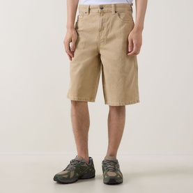 Model wearing Dickies 958 Loose Denim Shorts in Eucalyptus, styled with green trail trainers. Five-pocket design, loose fit.