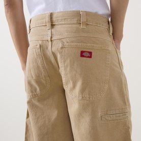 Model wearing Dickies 958 Loose Denim Shorts in Eucalyptus, showing back pockets with red logo patch, belt loops, loose fit, 100% cotton