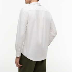 Model wearing Tommy Hilfiger shirt in Coastal Taupe stripe, back view, with olive green trousers