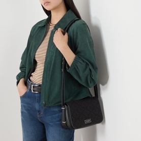 Model carrying Kate Spade Spade Flower Jacquard Small Flap Crossbody in black multi, silver-tone hardware, styled with green jacket and striped top