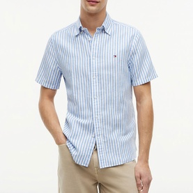 Model wearing Tommy Hilfiger short-sleeve shirt in Blue Spell stripe, styled with beige chinos