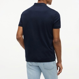 Model wearing Tommy Hilfiger navy blue polo shirt, back view, styled with light wash jeans