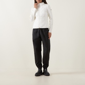 Model wearing Moncler natural cable-knit cotton cardigan with zip, styled with black tapered trousers and chunky black boots