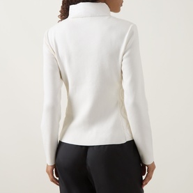 Model wearing Moncler Natural cardigan, rear view, turtleneck collar, fitted long sleeves, styled with black trousers