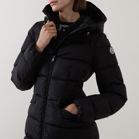 Model wearing Moncler black quilted hooded down coat with zip fastening and side pockets, styled with striped top