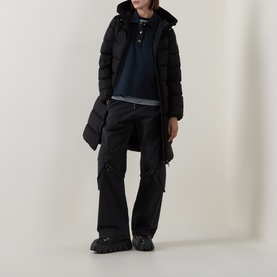 Model wearing Moncler black longline hooded puffer coat, styled with black cargo trousers and chunky boots