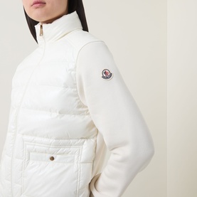 Model wearing Moncler Natural cardigan, close-up of quilted front panel, ribbed knit sleeve, and logo badge detail