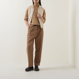Model wearing Moncler beige gilet with turtleneck, styled with tan trousers and black chunky loafers