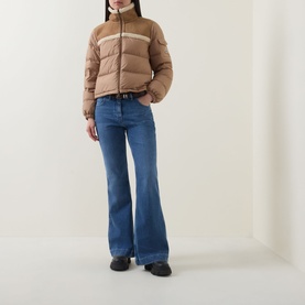 Model wearing Moncler brown wool puffer jacket with contrast stripe detail, styled with blue flare jeans and black boots