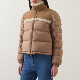 Model wearing Moncler brown quilted down jacket with shearling trim collar and stripe detail, styled with blue jeans