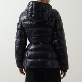 Model wearing Moncler black high-shine puffer jacket, rear view, featuring hood, quilted panels and belted waist.