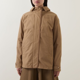 Model wearing Moncler brown hooded jacket with concealed zip fastening, gold-tone cuff hardware, styled with wide-leg trousers