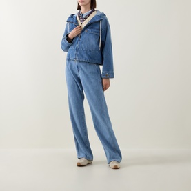 Model wearing Moncler blue padded jacket with hood, styled with matching wide-leg blue jeans and printed neck scarf.