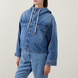 Model wearing Moncler blue denim hooded jacket with drawstring hood and chest pockets, styled with matching blue denim trousers.