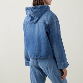 Model wearing Moncler blue denim hooded jacket, rear view, styled with matching blue denim jeans.