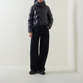 Model wearing Moncler Niveole Glossy Down Jacket in navy with detachable hood, styled with wide-leg black trousers and chunky boots.
