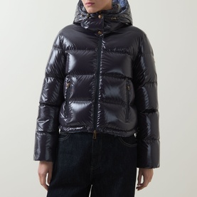 Model wearing Moncler Niveole Glossy Down Jacket in navy, boudin quilted with detachable hood, paired with dark jeans.